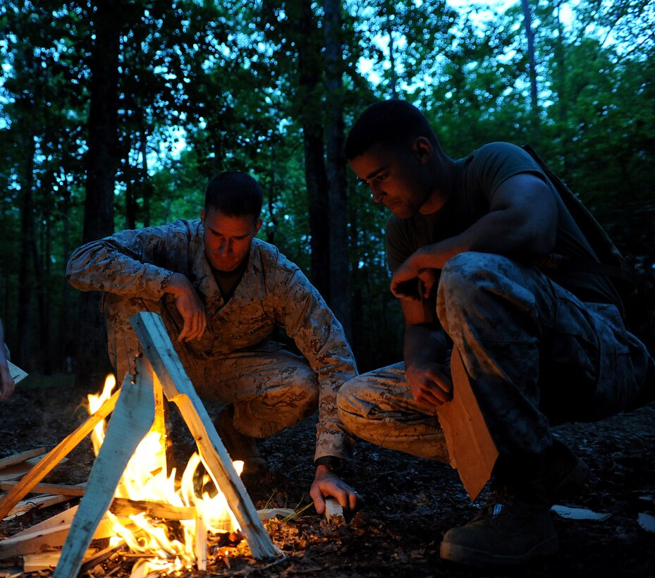Staff Sgt. James Woolford and Lance Cpl. Daniel Perez construct a fire to cook on during a field exercise at Marine Corps Base Quantico, Va., May 18. The field exercise allowed the Marines from Alpha Company, Marine Barracks Washington, to complete annual training. (Photo by Lance Cpl. Jeremy Ware)